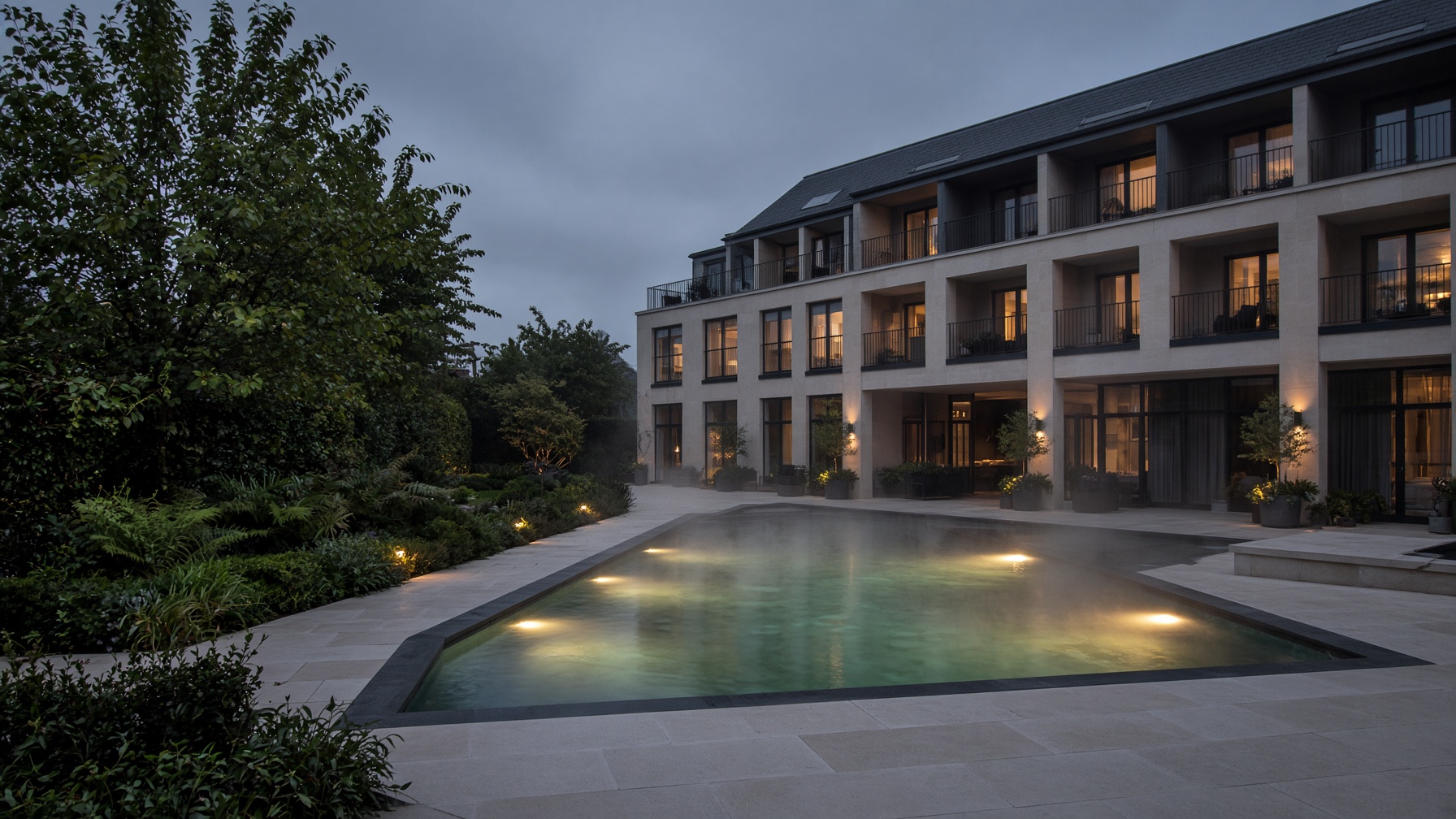 Hotel pool at dusk with steam rising from the water
